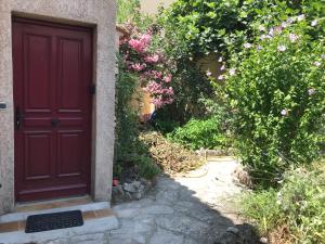 a red door on a house with pink flowers at Chambre climatisée avec sdb privée dans une villa avec piscine ouverte d'avril à mi octobre in Marseille