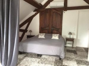 a bedroom with a white bed with a wooden cabinet at Autour d'une histoire in Sarlat-la-Canéda