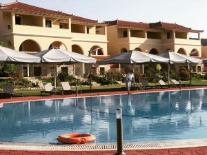 a person standing next to a swimming pool in a hotel at Aktaion Resort in Gythio