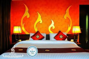 ein Schlafzimmer mit einem großen Bett mit roten und weißen Kissen in der Unterkunft Royal Thai Pavilion Jomtien Hotel in Jomtien Beach