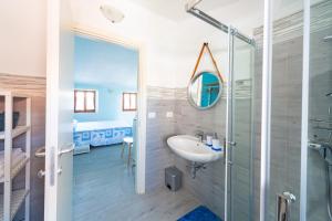 ein Bad mit einer Dusche, einem Waschbecken und einem Spiegel in der Unterkunft Aloha in San Benedetto del Tronto