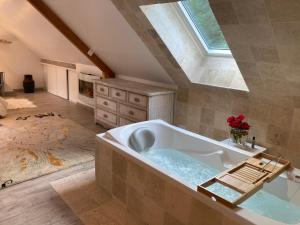 La grande salle de bains est pourvue d'une baignoire et d'une lucarne. dans l'établissement A 2 heures de Paris, Loft Romantique de 55 m2 en pleine nature entre campagne et mer, à Saint-Philbert-des-Champs