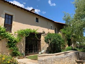 a house with a window in a yard at Grande villa au coeur de la Dordogne in Paussac-et-Saint-Vivien