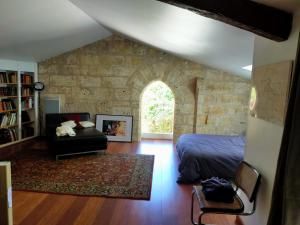 a bedroom with a bed and a stone wall at Grande villa au coeur de la Dordogne in Paussac-et-Saint-Vivien