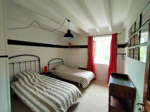 a bedroom with two beds and a window at Grande villa au coeur de la Dordogne in Paussac-et-Saint-Vivien