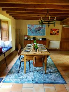 a dining room with a table and chairs on a rug at Grande villa au coeur de la Dordogne in Paussac-et-Saint-Vivien