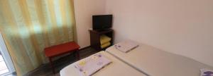 コスティネシュティにあるCasa Mihaiのベッド、椅子、テレビが備わる客室です。