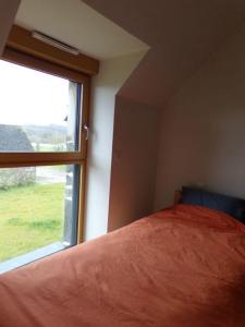 1 dormitorio con cama y ventana grande en LES REINETTES - Les Vergers de Guerlédan en Mur-de-Bretagne