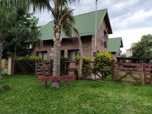 una casa con una palmera y una valla de madera en GRIMALDI en Colón