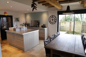 a kitchen with a wooden table and a dining room at La Maison de Louis in Francon