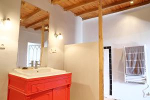a bathroom with a red cabinet and a sink at La Maison de Louis in Francon