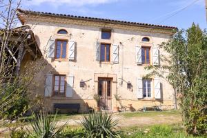 an old stone house with red windows at La Maison de Louis in Francon