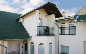 Casa blanca con balcón en la parte superior. en Apartmani Anton, en Osijek