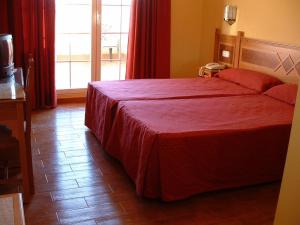 1 dormitorio con 1 cama grande con colcha roja en Villa de Gor, en Gor