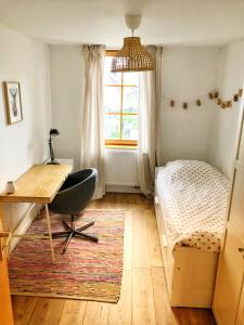 1 dormitorio con escritorio, 1 cama y ventana en Charming apartment Basel border - 3 bedrooms, en Hégenheim