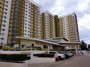 dos edificios altos con autos estacionados en un estacionamiento en Keys 'N Places Holiday Rentals at Mesaverte Condo, en Cagayan de Oro