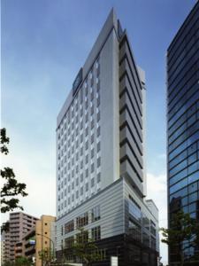 a tall building with a large clock on it's side at R&B Hotel Hachioji in Hachioji