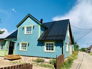 a blue house with a black roof on a street at Boutique Villa MAMELFA in Tiheda