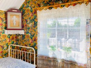 a bedroom with a window with a cross on the curtain at Boutique Villa MAMELFA in Tiheda