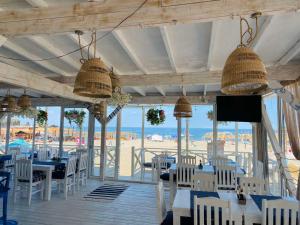 restauracja ze stołami i krzesłami oraz widokiem na plażę w obiekcie Primea Beach Residence w Carewie