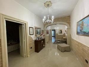 sala de estar con lámpara de araña y habitación con sofá en "Lu Barocco" a soli 10 min da Torre Lapillo, en San Pancrazio Salentino