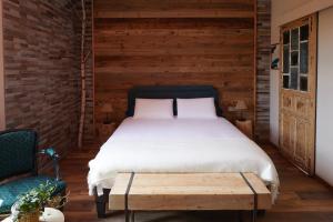 a bedroom with a bed and a wooden wall at Les Chambres - Au Grès du marché in La Petite-Pierre