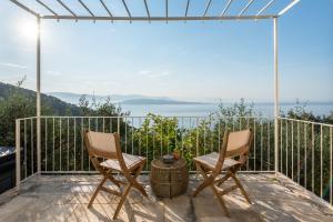 two chairs and a barrel on a balcony with a view at Rizes Sea View in Nisakion