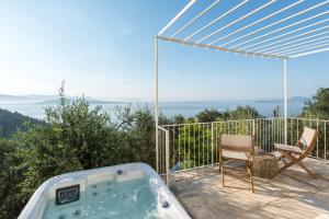 a bath tub sitting on a deck with a chair at Rizes Sea View in Nisakion