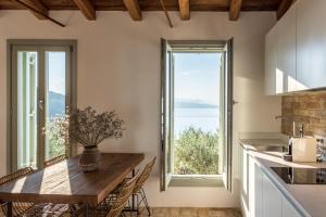 a kitchen with a table and a large window at Rizes Sea View in Nisaki