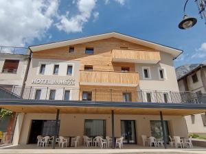 un hotel con mesas y sillas frente a un edificio en Hotel Da Marco, en Vigo di Cadore