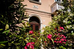 a building with a door and some pink flowers at Addler House Apt by Addler House Ospitality in Mestre