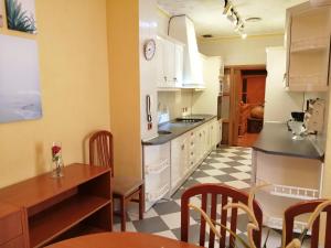a kitchen with white cabinets and a table and chairs at Casa Rural El Patio in Almadén +48 photos