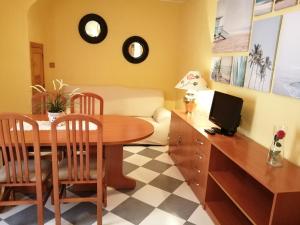 a dining room with a table and a couch at Casa Rural El Patio in Almadén