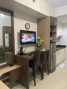a kitchen with a table and a tv in a room at 1 BR CONDO SEA RESIDENCES in Manila
