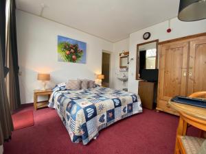 ein Schlafzimmer mit einem Bett und einem TV in der Unterkunft Hotel & Restaurant De Fortuna in Edam