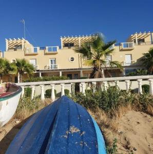 un bateau assis sur la plage à côté d'un bâtiment dans l'établissement En la playa, à Isla Cristina