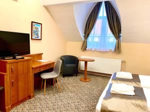 a hotel room with a desk and a tv at Borostyán Panzió in Kaposvár
