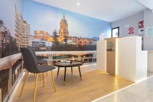 a room with a table and a chair on a balcony at Málaga Rivas 34 Suites Homes in Málaga