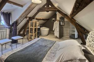 a attic room with a bed and a bath tub at La Collinière in Sainte-Gemme-Moronval
