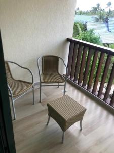 two chairs and a stool on a balcony at Studio Experience Marulhos Resort in Porto De Galinhas