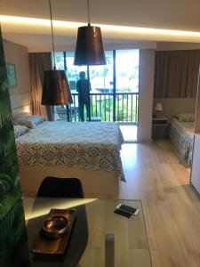 Studio Experience Marulhos Resort في بورتو دي غالينهاس: غرفة الفندق بسرير وطاولة مع صينية