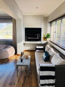 a living room with a couch and a bed at Whale Bay Villa in Fish hoek