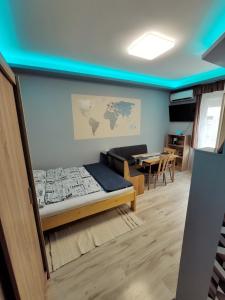 デブレツェンにあるBelvarosi Exkluzív Minigarzonのベッドとテーブルが備わる部屋