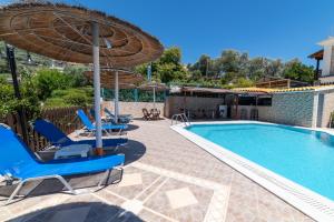 a swimming pool with lounge chairs and an umbrella at Lambrini Studios in Parga