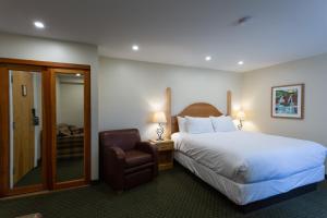 ein Hotelzimmer mit einem Bett und einem Stuhl in der Unterkunft Park Place Lodge in Fernie