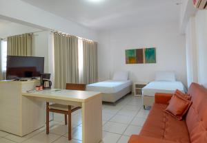 Uma TV ou centro de entretenimento em Best Western Suites Le Jardin Caldas Novas
