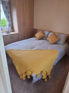 a bedroom with a bed with a yellow blanket on it at elbry in Heysham