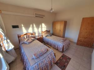 1 dormitorio con 2 camas y ventana en 4 Soles en San Rafael