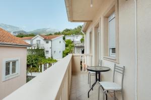 - un balcon avec deux chaises et une table dans un bâtiment dans l'établissement Todorovic apartmani, à Herceg-Novi