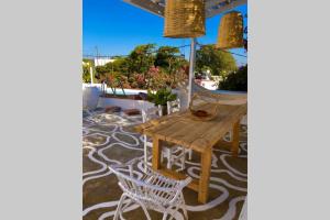 a wooden table and chairs on a patio at The Summer Pink House in Lachania